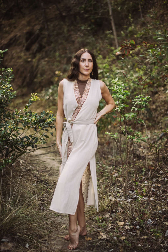 Woman in a white dress standing in a forest