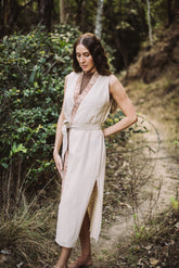 Woman in a flowing dress standing on a forest path